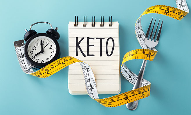 Keto word with clock fork and measuring tape around, intermittent fasting on keto concept