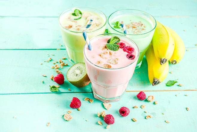 Summer refreshing drinks - protein shakes, milkshakes or smoothies, with fresh berry and fruits, light blue table copy space
