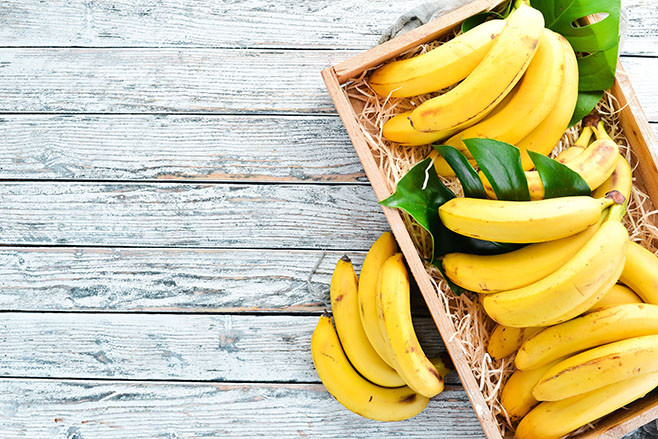 Fresh bananas in a wooden box. Top view. Free copy space.