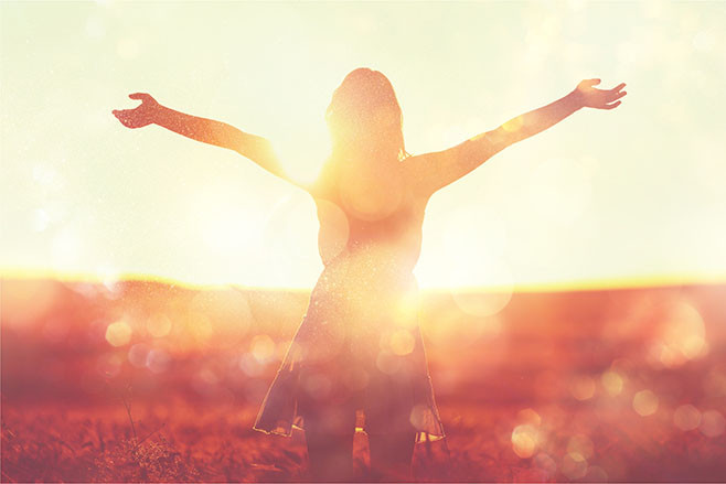 Young woman on field under sunset light