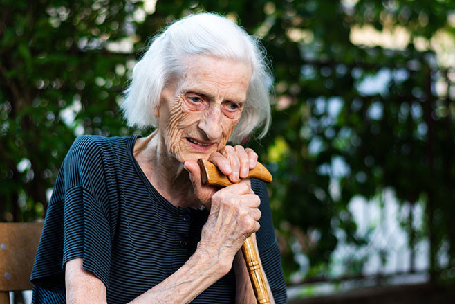 Portrait of a senior woman with a walking cane outdoors