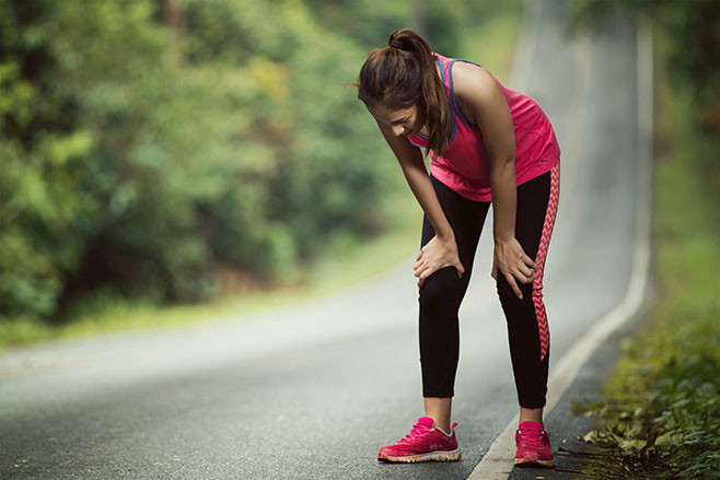 Woman is tired from jogging on a steep slope