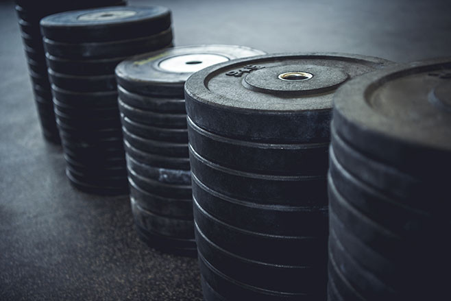 Different black weights arranged and lined up.