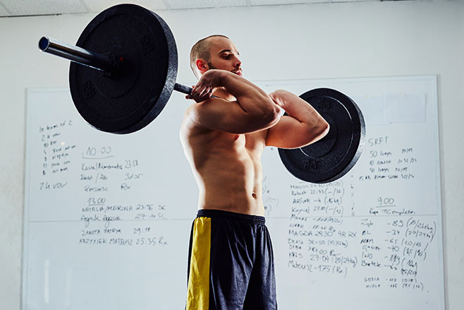 Clean exercise - young athlete doing functional workout at the gym