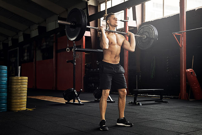 Young muscular man during his weightlifting workout in the gym