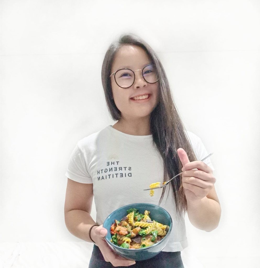 Valentina smiling and holding a bowl of pasta 